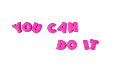Text YOU CAN DO IT spelled with vivid pink alphabet shaped cookies on white background