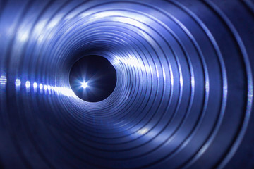 closeup view from inside the galvanized steel air duct on the exhaust fan in the background light,...