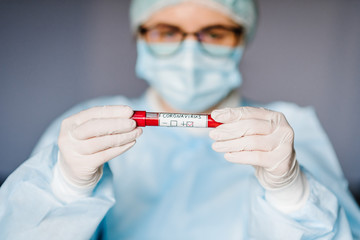 Epidemic Corona virus. Doctor holding a blood test, positive result, rapidly spreading Coronavirus, China. Tube with sample blood for 2019-nCoV.