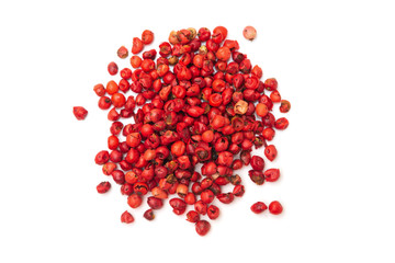 Pile of pink pepper corns on white background