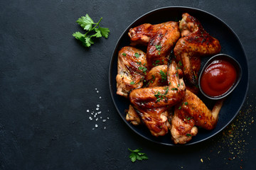 Grilled spicy chicken wings with ketchup. Top view with copy space.