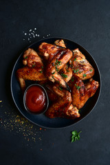 Grilled spicy chicken wings with ketchup. Top view with copy space.
