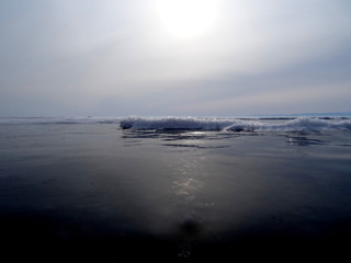 Fototapeta premium a lake covered with smooth dark ice in the evening twilight