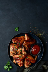 Grilled spicy chicken wings with ketchup. Top view with copy space.