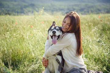 Beautiful woman playing with husky dog outdoors at park. © Olena_Molchanova