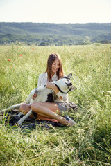 Beautiful woman playing with husky dog outdoors at park.