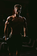 Fototapeta na wymiar muscular man with weights in gym
