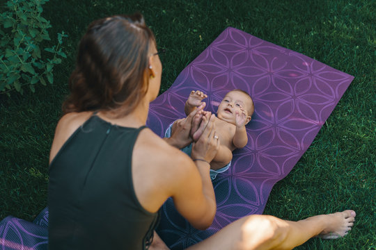 Mother doing baby yoga for her son