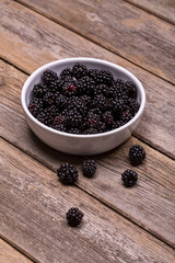 Fototapeta na wymiar Fresh blackberries in white ceramic bowl