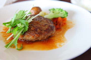 Hamburg and vegetables in a white dish Is a western style food that is applied in Japanese style. Is a popular food at home of Japanese people