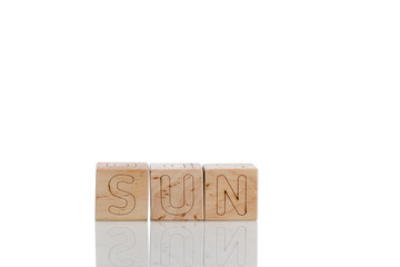 Wooden cubes with letters sun on a white background