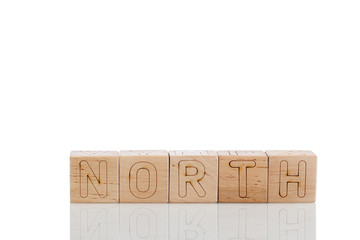Wooden cubes with letters north on a white background