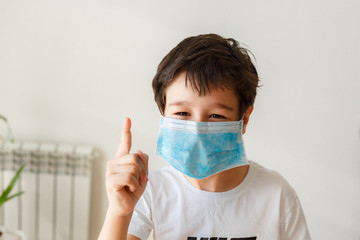 Cute little asian  boy wearing health mask, looking up, isolated over white background