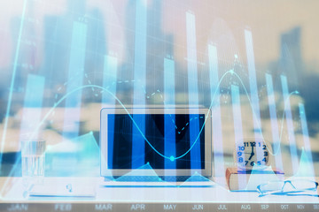 Forex graph hologram on table with computer background. Multi exposure. Concept of financial markets.