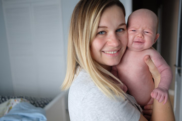 Pretty woman holding a newborn baby in her arms