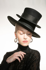 A blonde girl on a white background, two hats on her head