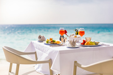 Luxury breakfast food on white table, with beautiful tropical sea view background, morning time summer holiday and romantic vacation concept, luxury travel and lifestyle