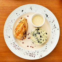 Delicious chicken breast with rice on a plate, top view.