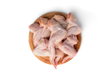 Raw chicken wings on wooden board isolated on white background.