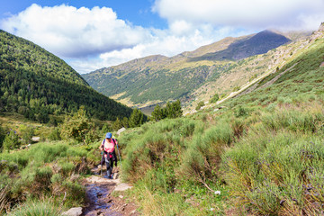 View of lady hiker, going up to the lakes of Juclar with the Incles Valley in the background....