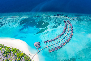 Fototapeta na wymiar Perfect aerial landscape, luxury tropical resort or hotel with water villas and beautiful beach scenery. Amazing bird eyes view in Maldives, landscape seascape aerial view over a Maldives