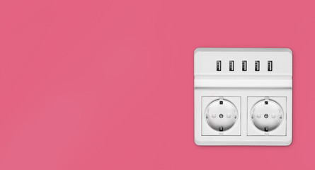 white electric socket on a pink wall with copy space