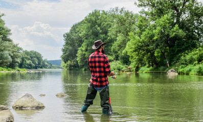 hobby and sport activity. pothunter. bearded fisher in water. fisherman with fishing rod. mature man fly fishing. man catching fish. summer weekend. Big game fishing. An old angler lives here.