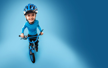 little boy with a bicycle in a helmet on a blue background. top view.