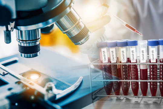 lab technician assistant or doctor or scientist analyzing a blood sample at laboratory with microscope. Medical, pharmaceutical and scientific research and development new Covid-19 vaccine concept