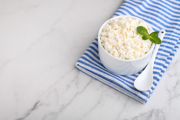 Cottage cheese in a white ceramic form on a marble background