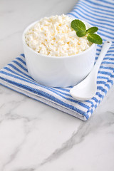 cottage cheese in a white ceramic form on a marble background
