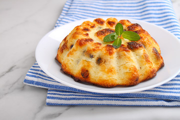 Cottage cheese casserole decorated with mint on a marble background