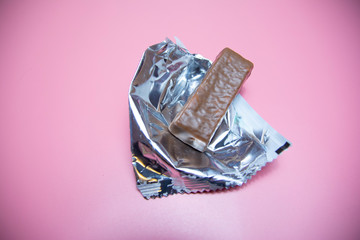 chocolate protein bar healthy food on a pink background