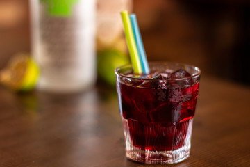 cherry alcohol drink with color straws on wooden table