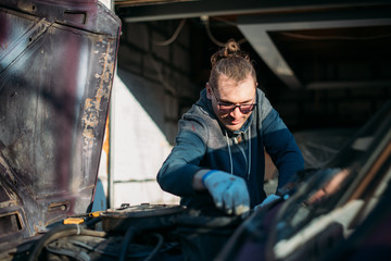 Fototapeta na wymiar A man repairs a car, opens the hood