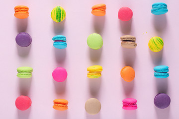 Creative composition with envelope and cake macaron or macaroon on pink pastel background top view. Flat lay.