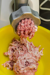 Meat is minced in an electric meat grinder