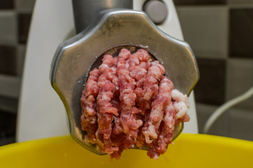 Meat is minced in an electric meat grinder