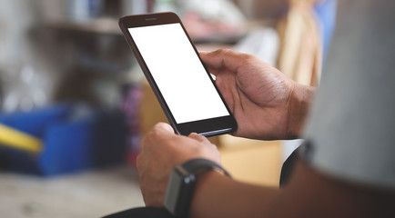 Cropped shot view of man hands holding smart phone with blank copy space screen for your text message or information content, female reading text message on cell telephone during in urban setting.