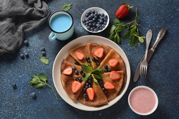 Sweet pancakes wrapped with fresh blueberries , mint, strawberries. Healthy breakfast concept