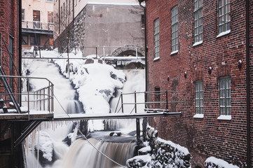 Winter waterfall at old industrial buildings, Sweden.