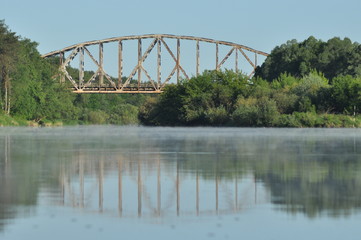 Railway bridge over the river. Bug valley. View of the metal structure of the river.