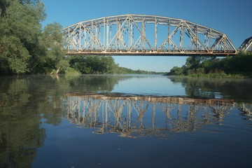 Naklejka premium Railway bridge over the river. Bug valley. View of the metal structure of the river.