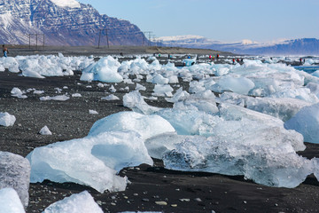beautiful blue and white ice on black volcanic sand on 