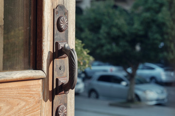 An open wooden door with old metal door handles