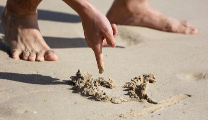 A boy is playing in the sand of a beach.
