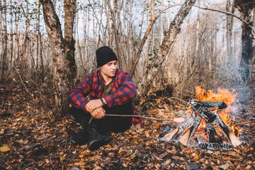 A man sitting near the campfire and enjoy the atmosphere.