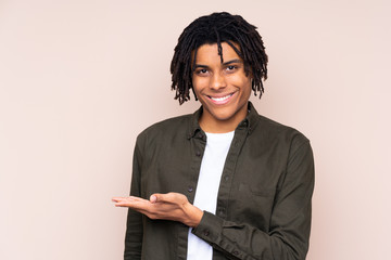 Young African American man over isolated background presenting an idea while looking smiling towards