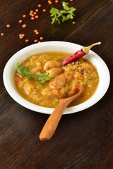 Dal, red lentil soup with turmeric, garlic, chili and cilantro. Indian food, vertical