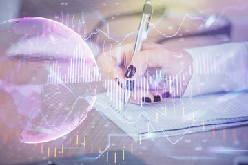 Multi exposure of hands making notes with forex chart huds. Stock market concept.